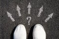 Choice of solutions, paths, strategies. Sneakers and arrows in different directions on asphalt. The concept of choice. Business