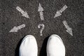 Choice of solutions, paths, strategies. Sneakers and arrows in different directions on asphalt. The concept of choice. Business