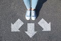 Choice of way. Woman standing in front of drawn marks on road, closeup. White arrows pointing in different directions Royalty Free Stock Photo