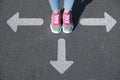 Choice of way. Woman standing in front of drawn marks on road, closeup. White arrows pointing in different directions Royalty Free Stock Photo