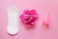 Women intimate hygiene products, sanitary pad, reusable silicone menstrual cup and beautiful fresh peony flower on pink background Royalty Free Stock Photo