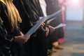 Choir singers holding musical score and singing on student gradu