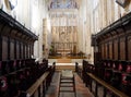 Choir stalls in church interior with rows of pews and steps leading up to the altar