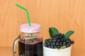 Chokeberry or Aronia melanocarpa juice with ice in glass with straw and berry in basket