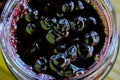 Chokeberry berry jam in a glass jar. Sweet from aronia