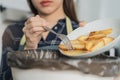 Cholesterol of junk meal is fat meal, hand of asian young household woman scraping, throwing food leftovers into garbage, trash Royalty Free Stock Photo