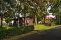 Chomutov, Czech republic - June 10, 2018: wooden cottage between big trees in autocamp with path in foreground for tourist leading Royalty Free Stock Photo