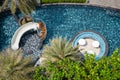 CHON BURI, THAILAND - FEBRUARY 16, 2019: Top view of tropical swimming pool, water slide, seats and table in the pool at the