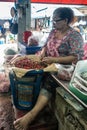 Woman cleans red chilli peppers on Nong Mon Market in Chon Buri, Thailand