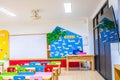 Desks, chairs and white board in the kindergarten classroom. And there are beautifully decorated knowledge boards