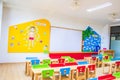 Desks, chairs and white board in the kindergarten classroom. And there are beautifully decorated knowledge boards Royalty Free Stock Photo