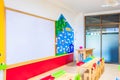 Desks, chairs and white board in the kindergarten classroom. And there are beautifully decorated knowledge boards