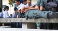 CHONBURI, THAILAND-AUGUST 3, 2017 : Schoolboys wear military students uniform lying on a bench made of cement in school