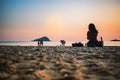 CHONBURI / THAILAND - January 04 2020 : Silhouette Young woman is sitting on sand with the sunset background