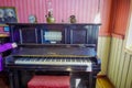 CHONCHI, CHILE, SEPTEMBER, 27, 2018: Indoor view of black piano inside of museum of chonchi filled with furniture and