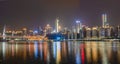 Chongqing, China - Dec 22, 2019: Night neon light pano view of historic Hongya cave by river with qian si men bridge