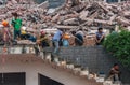 Demolition crew take lunch breat on pile of rubble downtown Chongqing, China