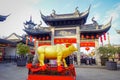 CHONGYUANG TEMPLE, CHINA: Golden bull statue standing in front of beautiful temple building