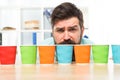Choose from alternatives. Man bearded choosing one of lot colorful paper cups. Alternative concept. Pick one. Diversity