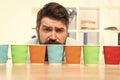 Choose from alternatives. Man bearded choosing one of lot colorful paper cups. Alternative concept. Pick one. Diversity