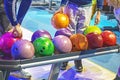 choose multi-colored balls according to their heaviness for the game of bowling.