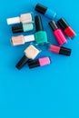 Choose nail polish. Polish bottels on blue background top view copy space