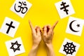 Choose religions concept. Hands point on Christianity, Catholicism, Buddhism, Judaism, Islam symbols on yellow Royalty Free Stock Photo