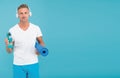 Choose sport drink wisely. Athletic man hold sport bottle and gym mat. Handsome sportsman blue background. Hydration for Royalty Free Stock Photo