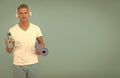 Choose sport drink wisely. Athletic man hold sport bottle and gym mat. Handsome sportsman blue background. Hydration for Royalty Free Stock Photo