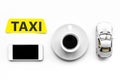 Choose a taxi in mobile application. Taxi label, cell phone, car toy on white background top view Royalty Free Stock Photo