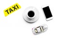 Choose a taxi in mobile application. Taxi label, cell phone, car toy on white background top view copyspace Royalty Free Stock Photo