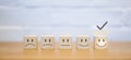 Chooses a smile face on wood block cube. Satisfaction survey. Questionnaire best excellent business services rating customer Royalty Free Stock Photo