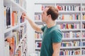 Choosing book in library or bookshop, student picking literature Royalty Free Stock Photo