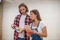 Young couple discussing the color for walls and looking involved