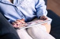 Choosing movie or series in online stream and video on demand VOD service. Woman using tablet on couch. Media streaming. Royalty Free Stock Photo