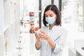 Choosing the right medicine. professional looking female pharmacist with medical mask on in drug store studying the Royalty Free Stock Photo