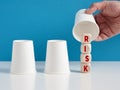 Choosing the risky option or making risky choices in business concept. Man playing the shell game with three cups reveals the word Royalty Free Stock Photo