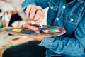 Choosing to live a colourful life. an unrecognizable artist squeezing paint onto a palette during an art class in the