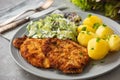 Chop pork cutlets , served with boiled potatoes and salad.