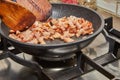 Chopped bacon with onions is fried in pan on gas stove Royalty Free Stock Photo
