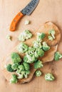 Chopped broccoli on a wooden cutting board on wooden background