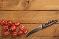 Chopped bunch tomatoes and knife on wood