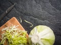 Chopped cabbage on a black stone background.
