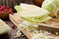 Chopped cabbage on a cutting board for making sauerkraut, coleslaw, salad or other cabbage dish. Bowl of cranberries