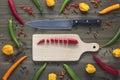 Chopped cayenne chilli pepper on cutting board with knife and cayenne chili peppers, habanero peppers, pepperoncino peppers and co Royalty Free Stock Photo