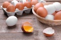 Chopped chicken egg with yolk close-up next to eggs in basket and tray on brown background Royalty Free Stock Photo