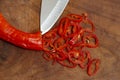 chopped chili on a exotic wood board with a knife tip