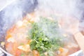 Chopped coriander, cilantro, or Chinese parsley being cooked