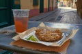 Chopped cutlet on a plate with citrus fruits, herbs and beer on a table outside. Generative AI