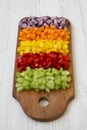 Chopped fresh vegetables arranged on cutting board on white wooden table, low angle view. Royalty Free Stock Photo